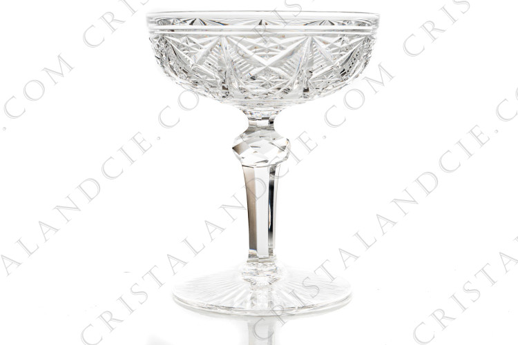 Coupe à Champagne en cristal de Baccarat forme 9056 taille 9058 présentant un décor de biseaux et étoile sur la paraison, une bague facettée et des côtes plates sur la jambe et une étoile à flammes sous le pied