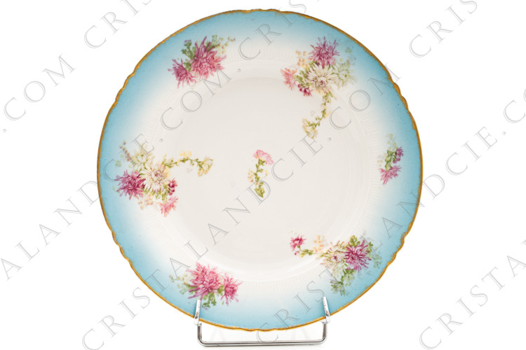 Grand plat rond creux en porcelaine de Limoges de la maison Sigismond Maas orné de chrysanthèmes rose et blancs sur un fond bleu clair et de liserets or