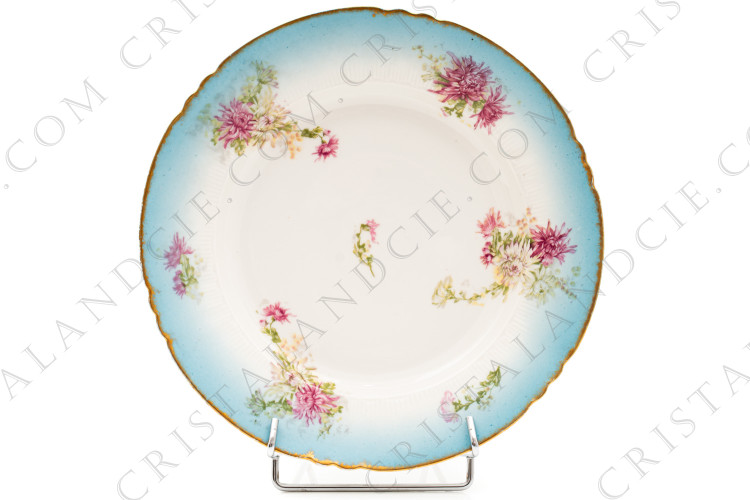 Petit plat rond creux en porcelaine de Limoges de la maison Sigismond Maas orné de chrysanthèmes rose et blancs sur un fond bleu clair et de liserets or