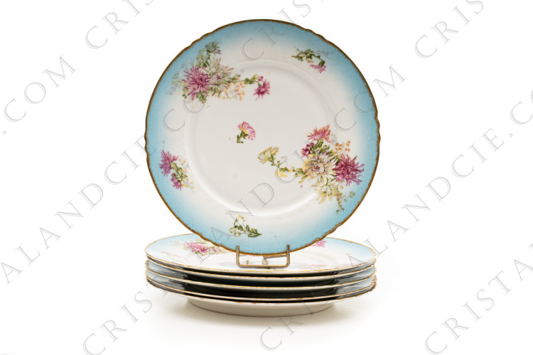 Série de six assiettes à dessert en porcelaine de Limoges de la maison Sigismond Maas ornées de chrysanthèmes rose et blancs sur un fond bleu clair et de liserets or