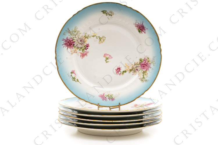 Série de six assiettes plates en porcelaine de Limoges de la maison Sigismond Maas ornée de chrysanthèmes rose et blancs sur un fond bleu clair et de liserets or