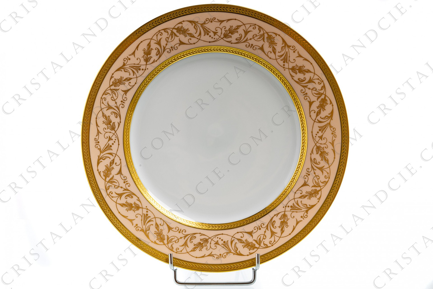 Dinner plate in Limoges china by Lafarge decorated with two gold inlays friezes of laurels and with gold arabesques of foliage on a pale pink background photo-1