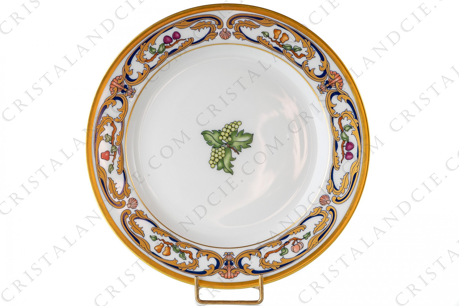 Assiette à salade en porcelaine de Limoges pour la maison Cartier modèle La Maison du Prince ornée d arabesque bleu de four et or 24 carats et de fruits polychromes sur le pourtour et de grappes de raisin au centre photo-1