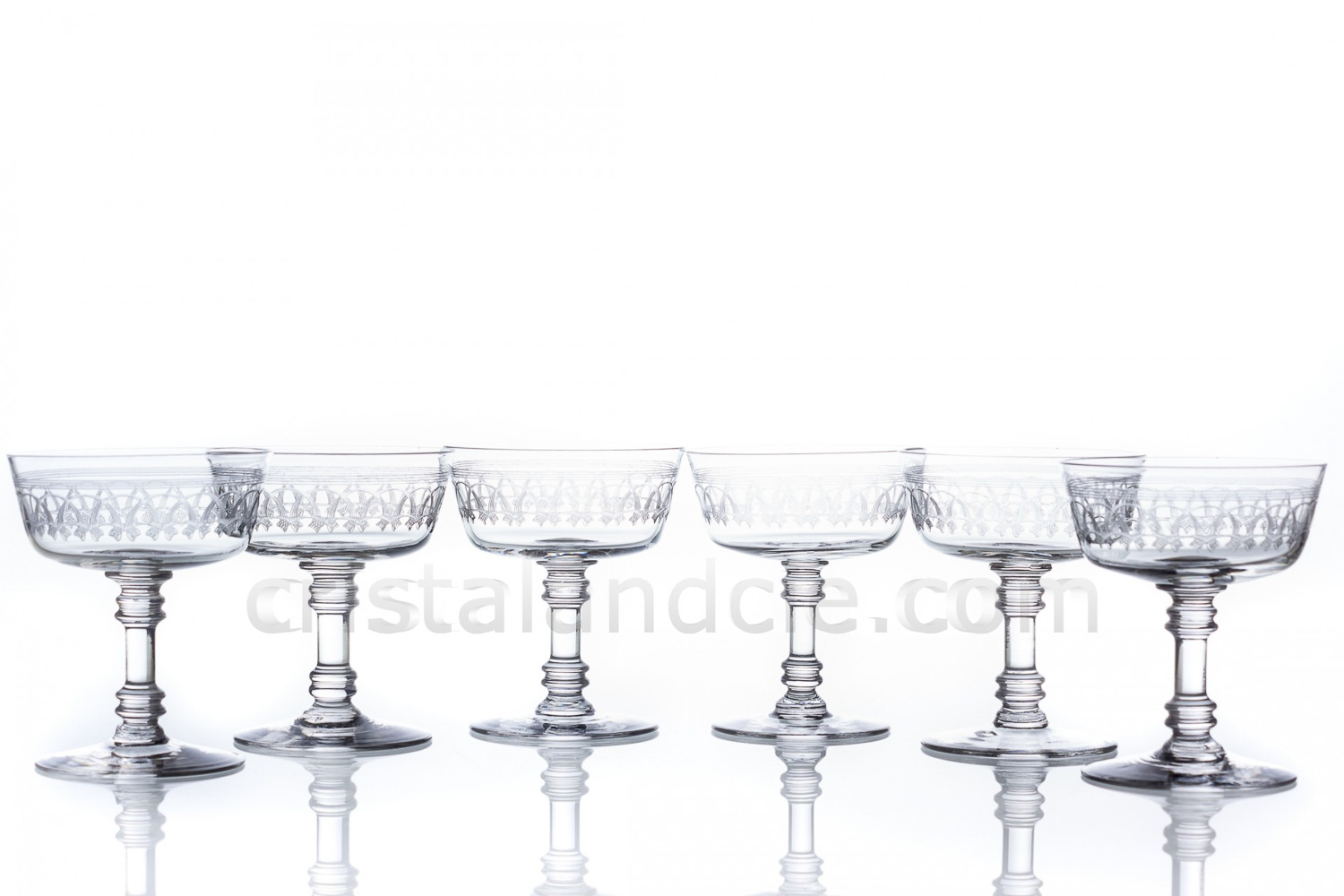 Série de six coupes à Champagne en cristal de Baccarat de forme cylindrique à jambe piédouche, présentant une frise gravée photo-1