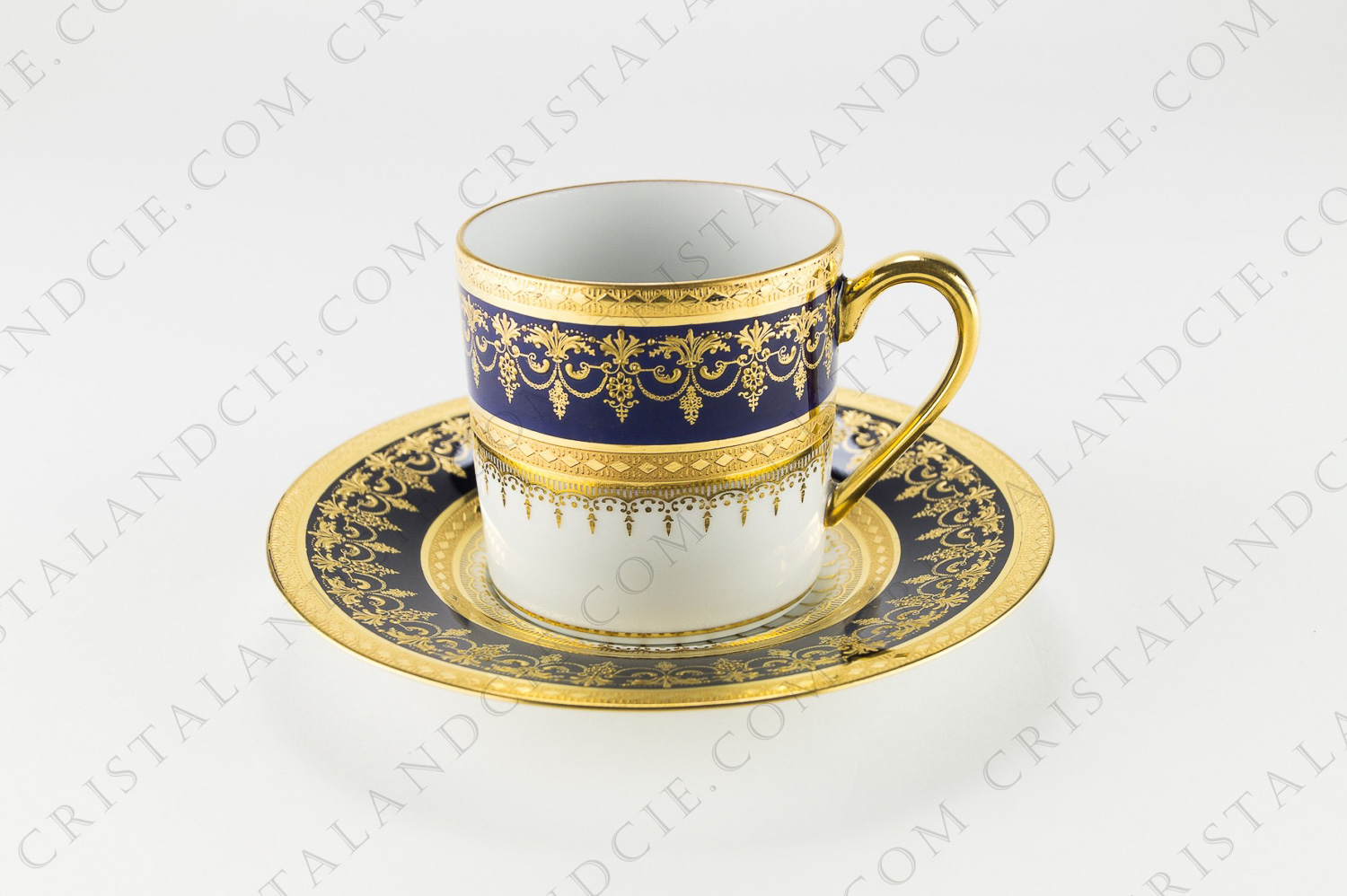 Tasse à café en porcelaine de Limoges de la maison Bernardaud modèle Chenonceaux ornée de rinceaux et frises en relief peint à la main à l or sur fond en bleu de four photo-1