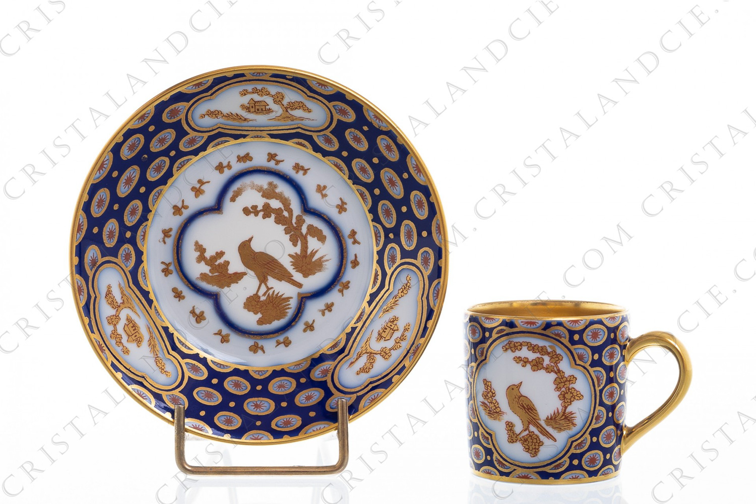 Tasse à moka en porcelaine de Limoges de la maison Bernardaud ornée d oiseaux et fleurs or sur un fond bleu de four photo-1