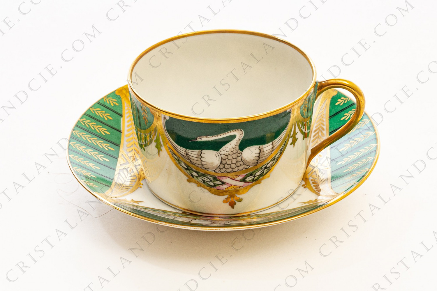Tea cup in china of Limoges by Charles Ahrenfeldt hand painted with swans on a green background, and green and gold garlands and friezes photo-1