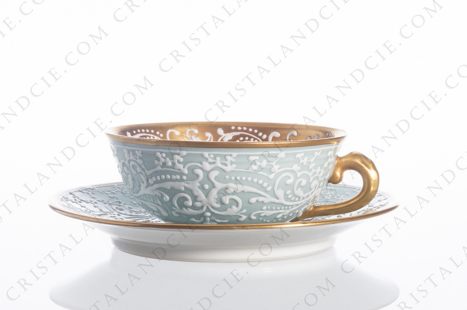 Tea cup in china decorated by the workshop Le Tallec in Paris, with an hand-enameled pattern of whites arabesques on a clear blue background photo-1